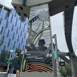 linocut print on monorail column of Artists at Play playground with a child swinging on a swing